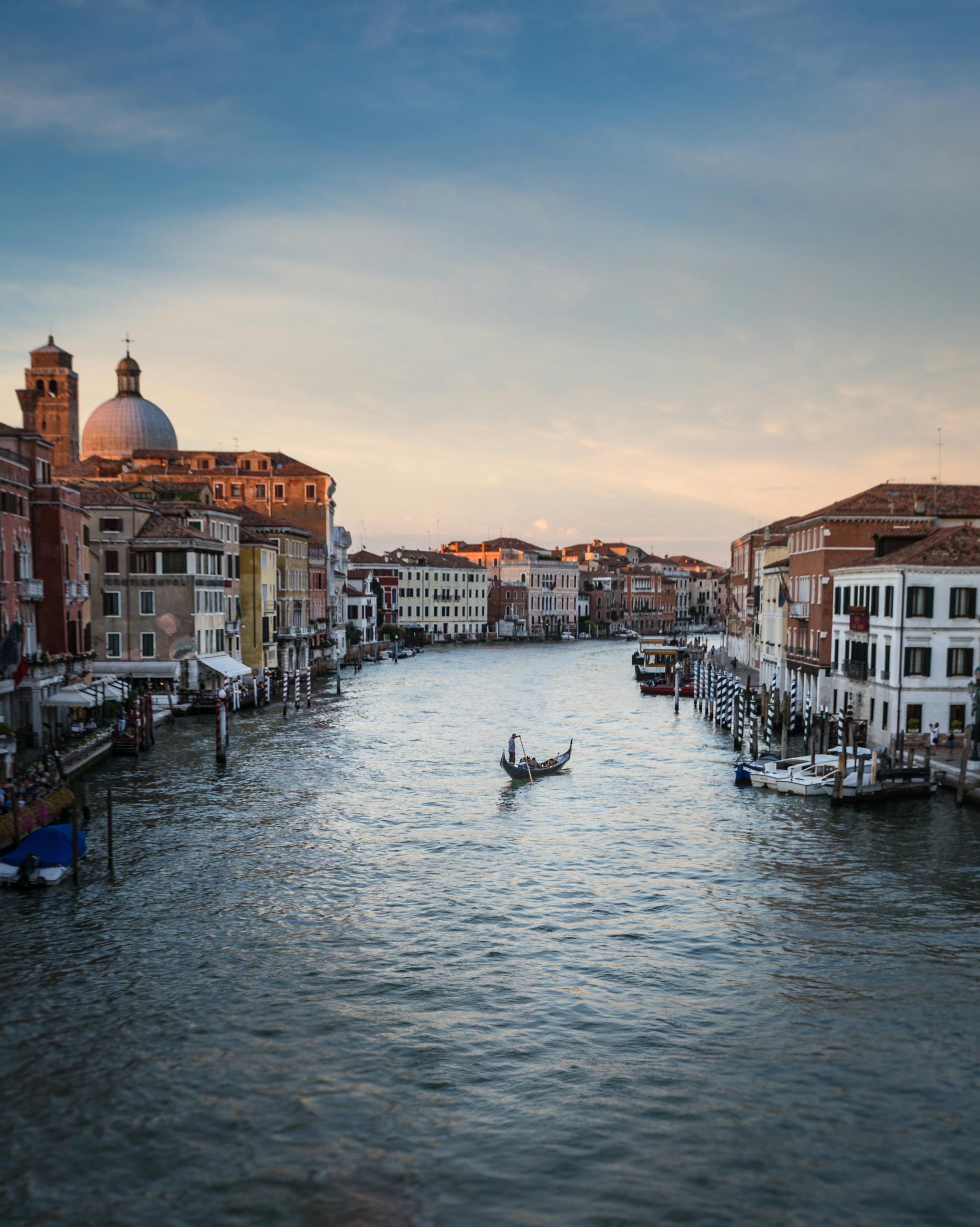 Beautiful view of the Venice Grand Canal with gondolas and historic architecture at sunset.